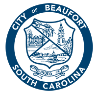 "City of Beaufort, South Carolina" written in a circle around a shield with a historic house, church tower, and boat in a bay. Under the shield is a banner "Founded 1711."
