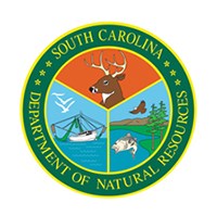 "South Carolina Department of Natural Resources" in a circle around a shield of a deer, shrimp boat, and a fish jumping out of a lake.