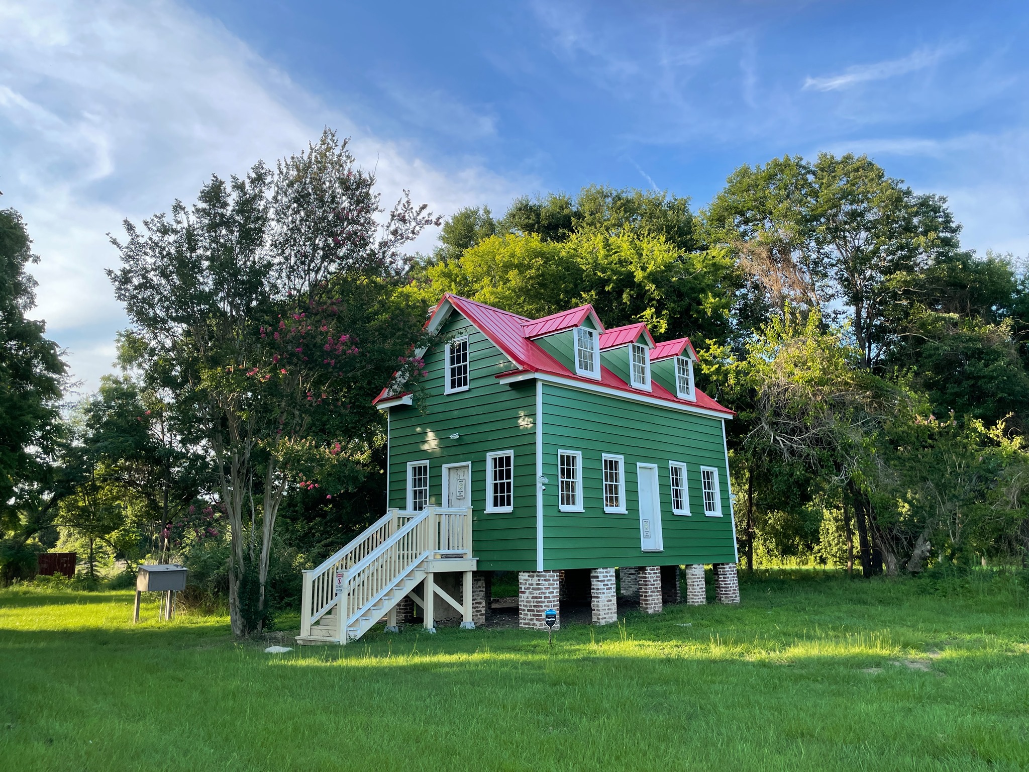 Hutchinson House Photo of a green house with red roof