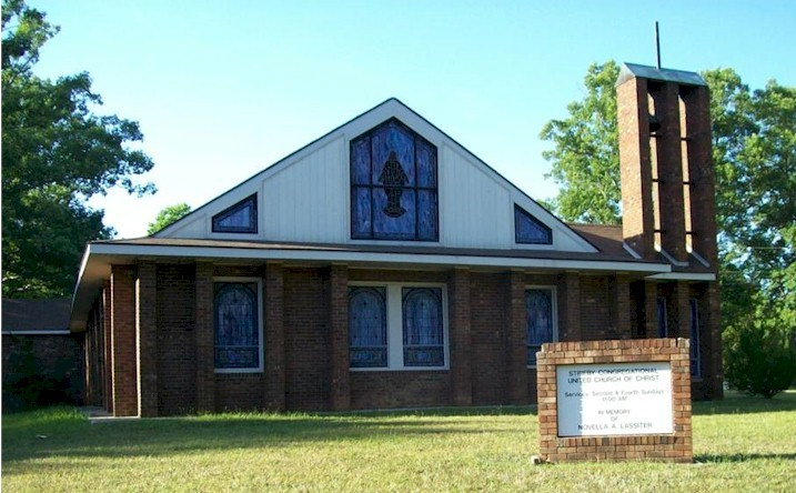 A mid 20th century brick church with a few stained glass windows