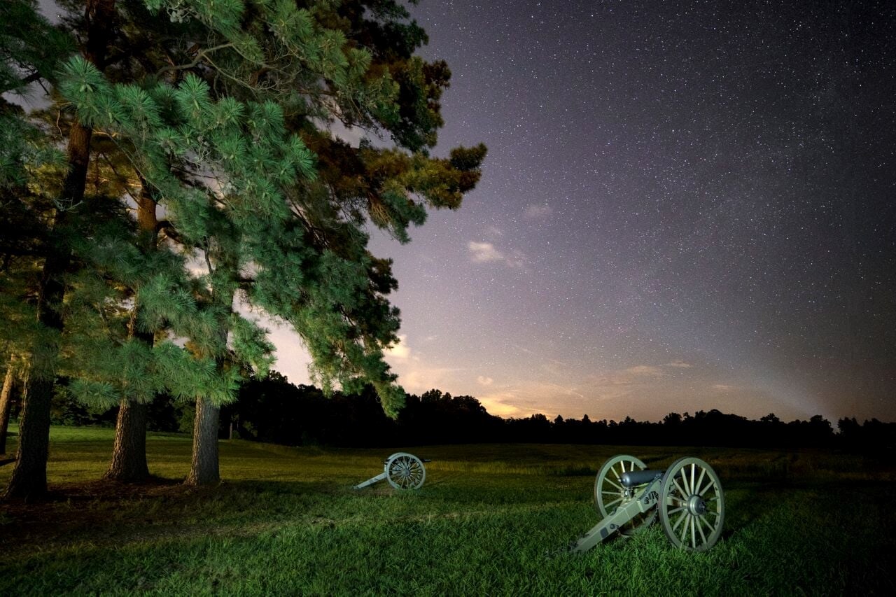 Civil War cannons under a starry night sky.