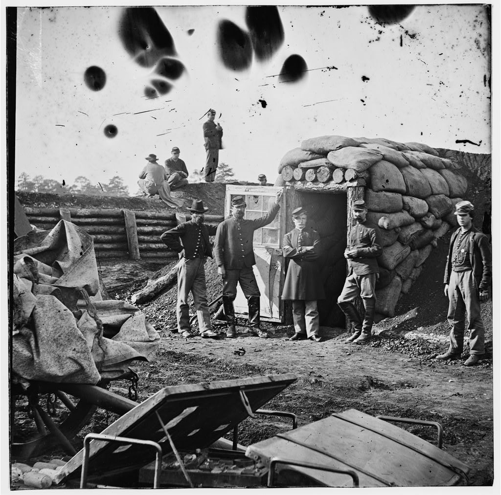 A historic image of the inside of Fort Harrison, circa 1864-1865. A group of five soldiers pose near the door of the bombproof.