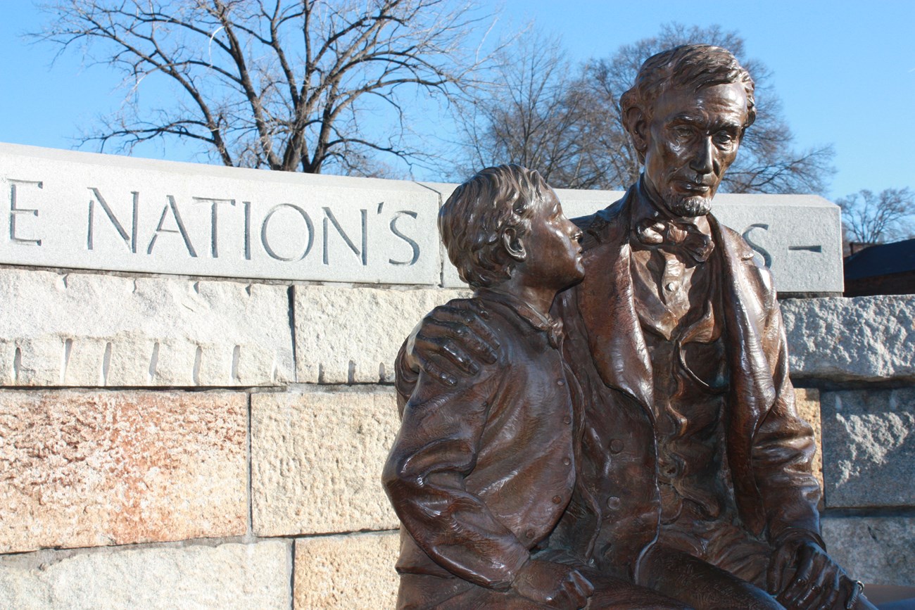 Bronze statue of Abraham Lincoln and his son, Tad, both seated.
