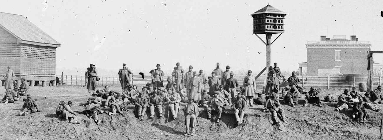 a black and white photo of African American Civil War soldiers at a river landing.