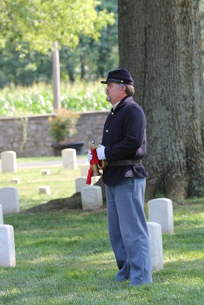 Memorial Day A Civil War Union soldier stands in a cemetery, holding a bugle