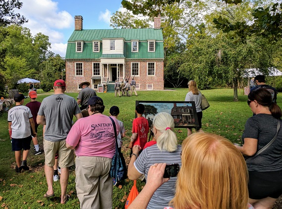 Join us for Harvest Day 2019! Visitors walk toward a brick plantation house