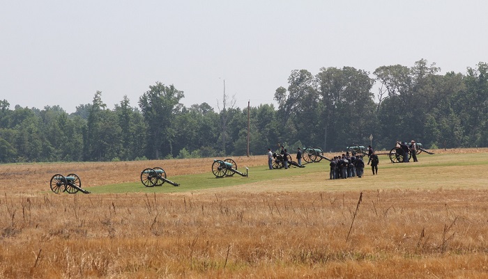 Artillery demonstrators and park rangers at Malvern Hill Civil War soldiers and a park ranger stand near 12 cannons