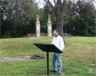 visitor reads wayside with two chimneys in background