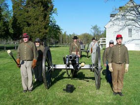 An artillery detachment prepares to fire a cannon.