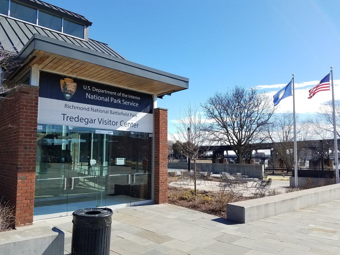 Large glass doors to a visitor center and two flagpoles.