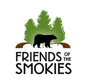 Black text that reads, "Friends of the Smokies", underneath a black bear silhouette in front of three green tree silhouettes and a brown pathway extending from either side of the trees.