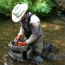A park biologist sampling insects in a stream.
