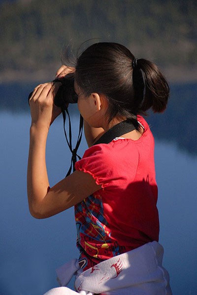 eyeing the deep A student peers through binoculars into Crater Lake.