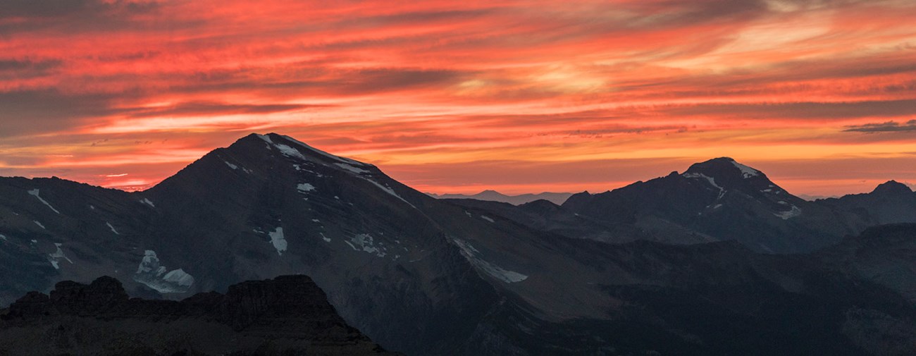 Pink and orange sunset over the peaks of Glacier.