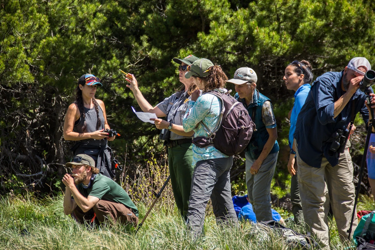 Park biologist trains citizen scientists on survey form. Park ranger explains survey form while surrounded by citizen scientists.