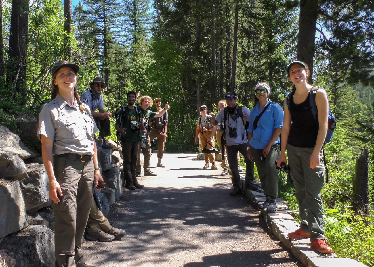 MCC crew and park staff pose for the camera MCC crew and park staff stand lined up on a paved path.