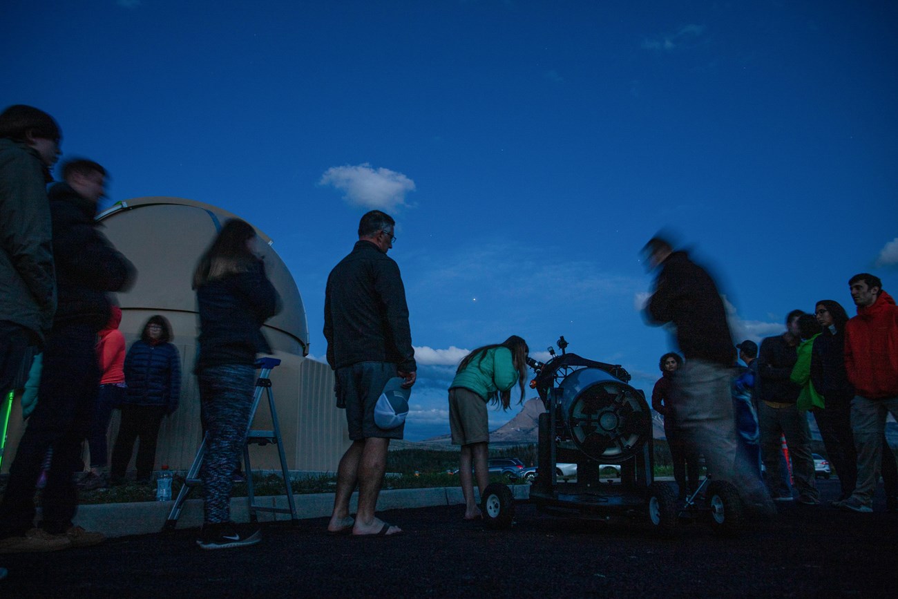 Telescope viewing A group of people look through telescopes at twilight
