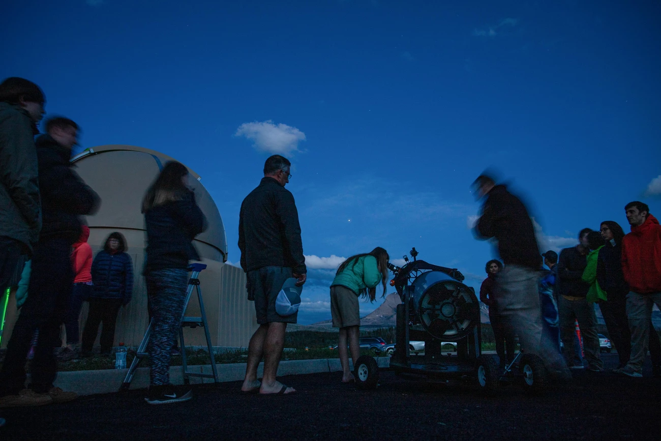 Telescope viewing A group of people look through telescopes at twilight