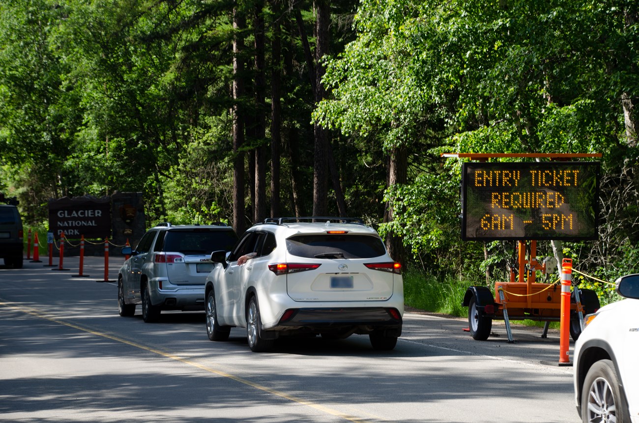 Ticketed Entry Sign A line of cars sit in front of a ticketed entry electronic traffic sign.