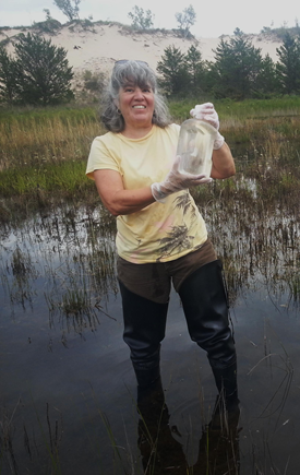lt= Dr. Joy Marburger holding water sample.