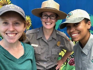 Close up of three young women smiling. One woman is wearing a ranger uniform.