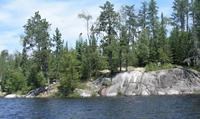 An island campsite seen from across a lake.
