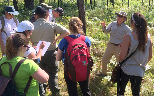 Several people are gathered together in tall grass.