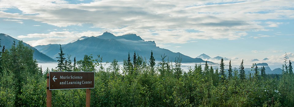 murie science and learning center sign with mountains in the background