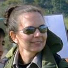 Photo of Marie Denn, a smiling white woman with sunglasses and dark hair pulled back.