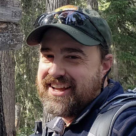 Headshot of Jason Ransom, a smiling white man outdoors with a beard and a ball cap.