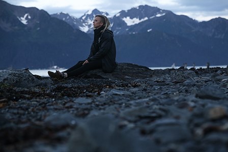 2016 OASLC Intern Anne Langdon sitting on the beach in Seward, Alaska