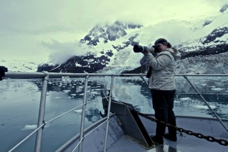 lt= photo of a woman using a camera on a boat