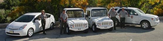 Park staff members stand with energy efficient vehicles