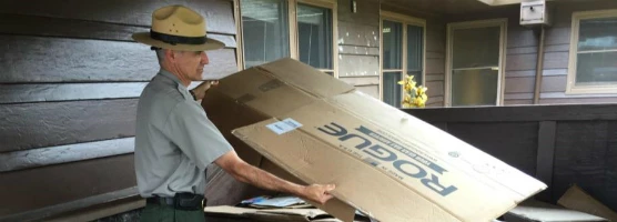 A staff member recycles cardboard at his park