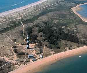 lt= The Cape Lookout lighthouse sits close to the coast line on one of the barrier islands