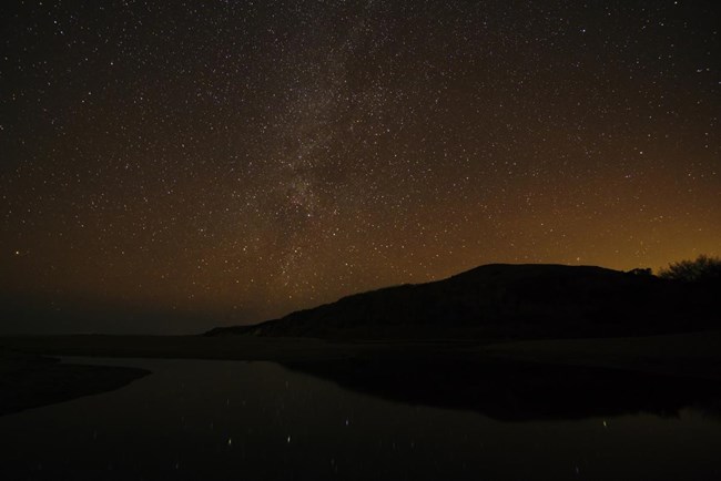 Milky Way at Point Reyes The Milky Way visible over a creek flowing across the beach and into the ocean, with light pollution also obvious on the horizon
