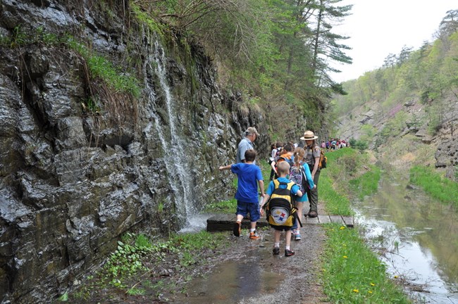 Students on a Field Trip walking along the muddy CnO Billy Goat Trail