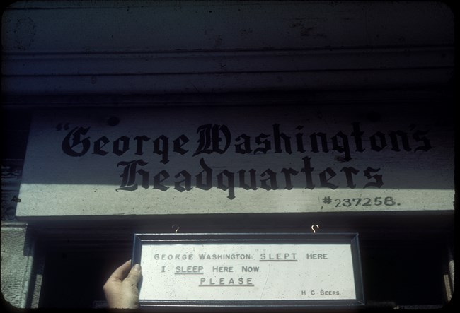 Two signs: One stating that the building is Washington's headquarters the other stating that George Washington had slept there and that someone else was sleeping there now.