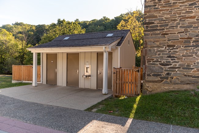 exterior of a small restroom building with three doors