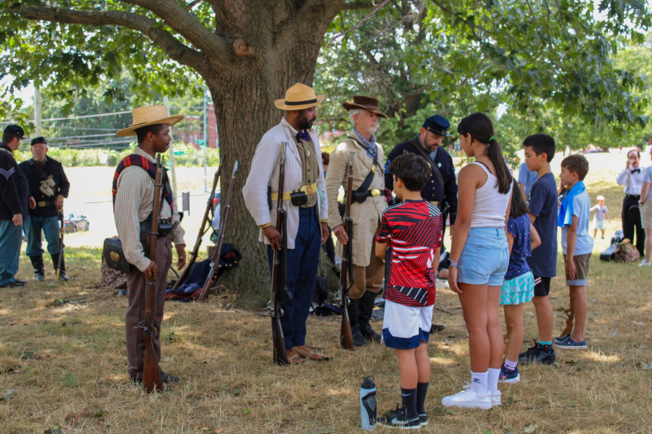 Four Civil War living history interpreters teach five children the drills.