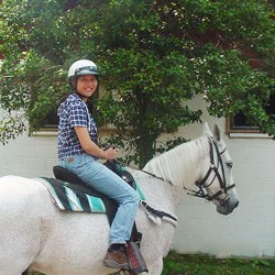 A young woman rides a horse at the Rock Creek Park Horse Center