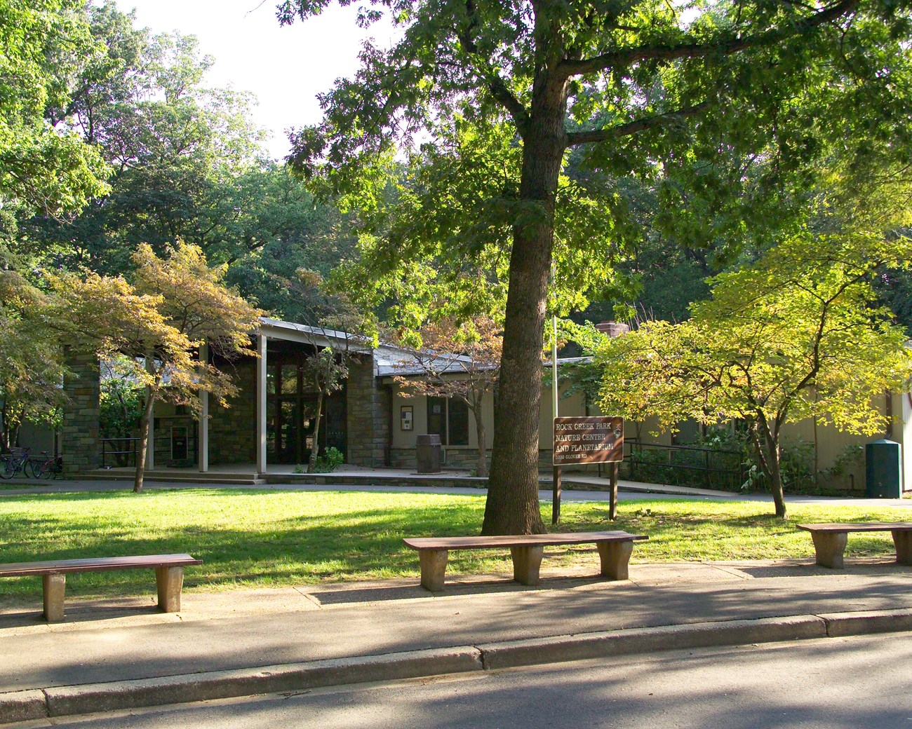 A one story building nestled among green leafy trees