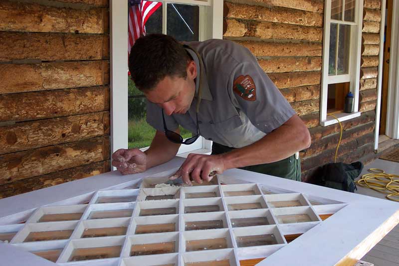 a photo of an historic preserver working on a door