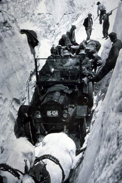 a photo of horses towing a car through the snow