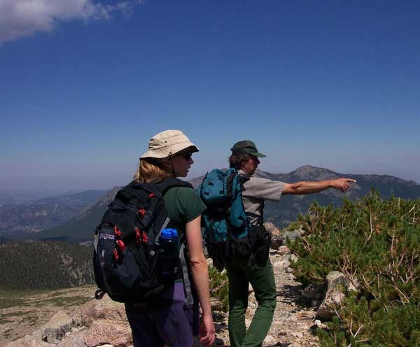 a photo of ranger viewing historic resources on Longs Peak trail