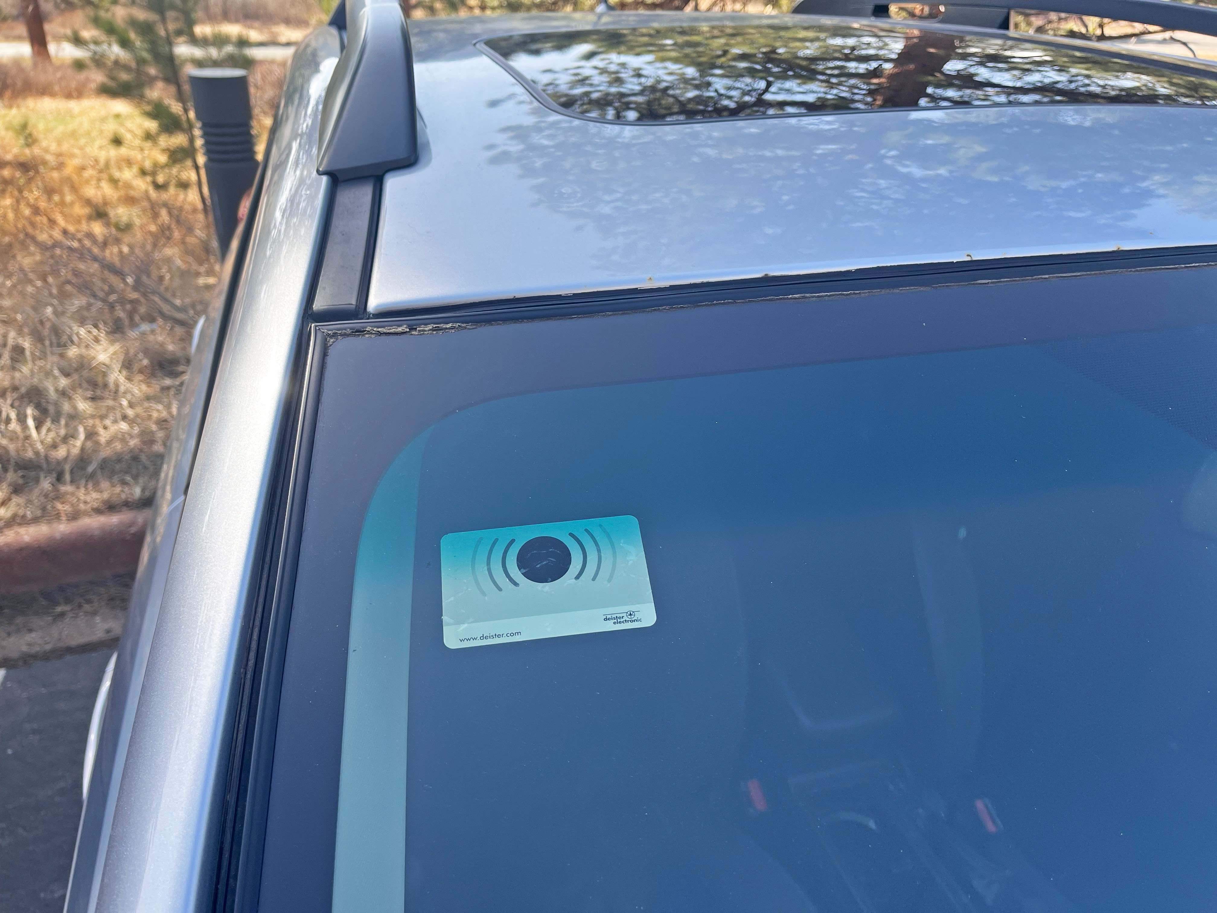 Courtesy RMNP_A transponder device that has been correctly placed on the inside of vehicle's windshield A credit-card sized device has been placed on the inside of a passenger vehicle's windshield. The device is affixed on the top right-hand side.