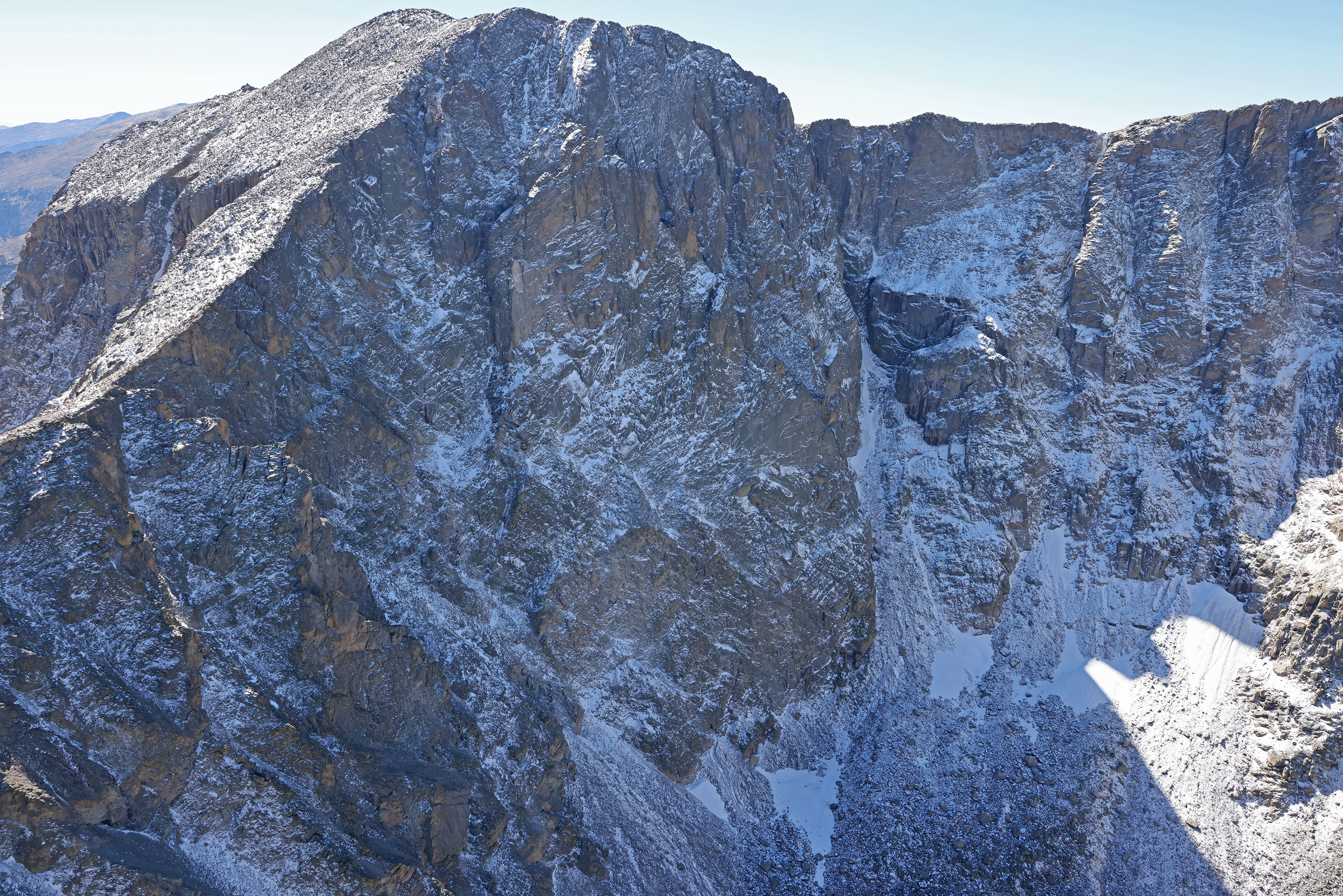 Steep mountain terrain with rocks and boulders covered in recent snow on Mount Alice