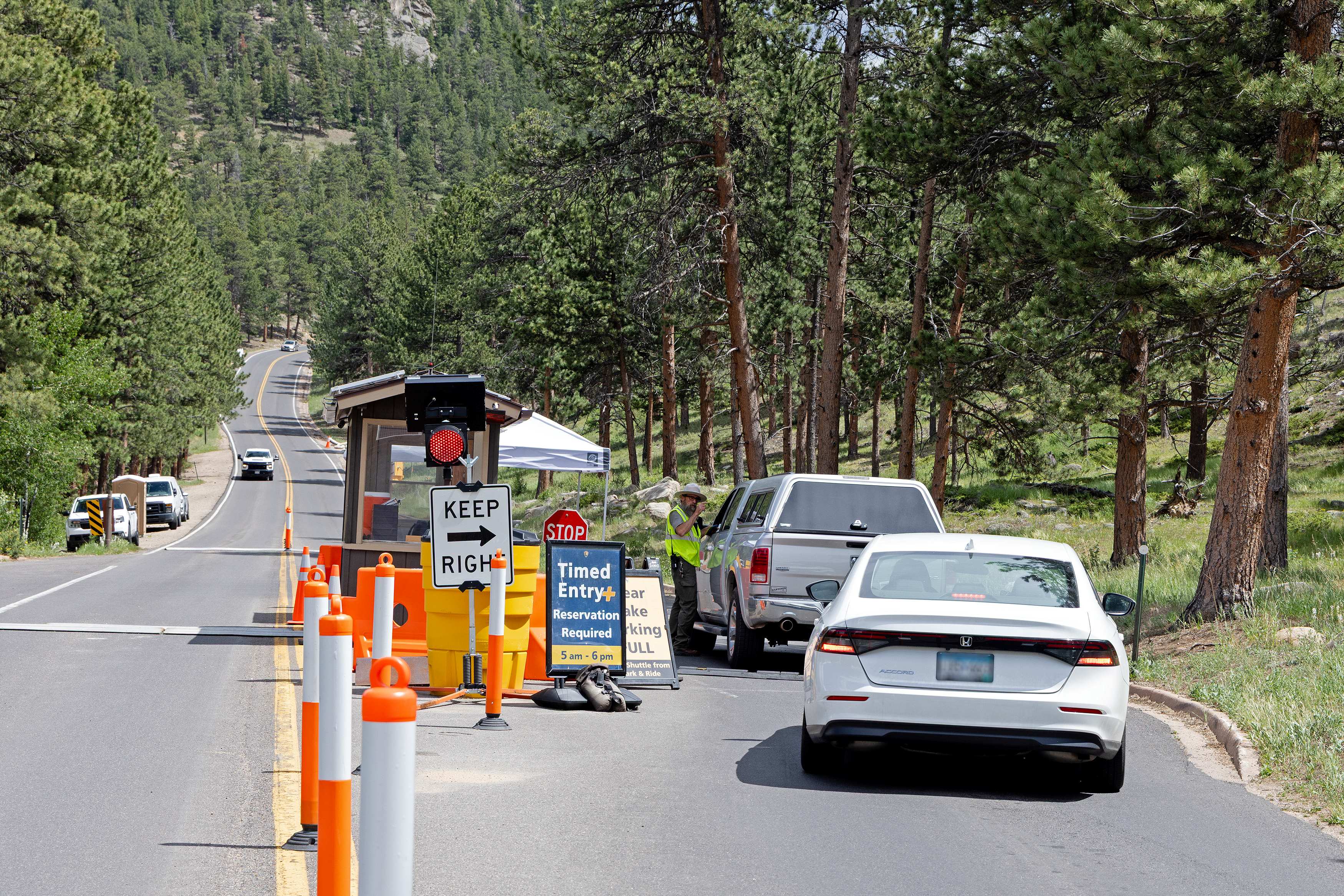 Courtesy RMNP_Park Ranger at Bear Lake Kiosk A Park Ranger is checking timed entry reservations at the Bear Lake Road kiosk