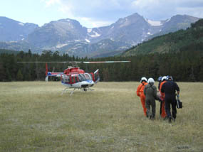 Photo park rangers carry cardiac patient to helicopter after being carried out from the Flattop Mountain Trail.