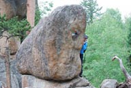 Photo Renelle waving through hole in rock.